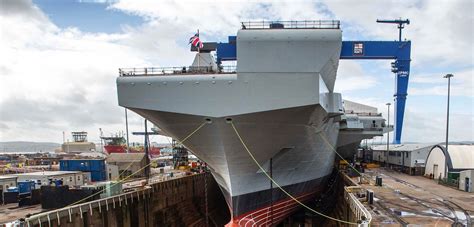 Aircraft carrier in a dry dock, undergoing maintenance.