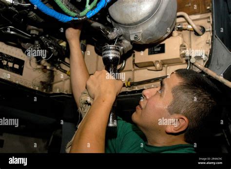 Aviation Machinist Mate working on an aircraft engine