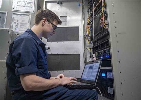 Information Systems Technician repairing a computer system