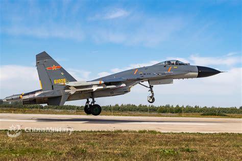 Maintenance personnel working on a J-11 fighter jet