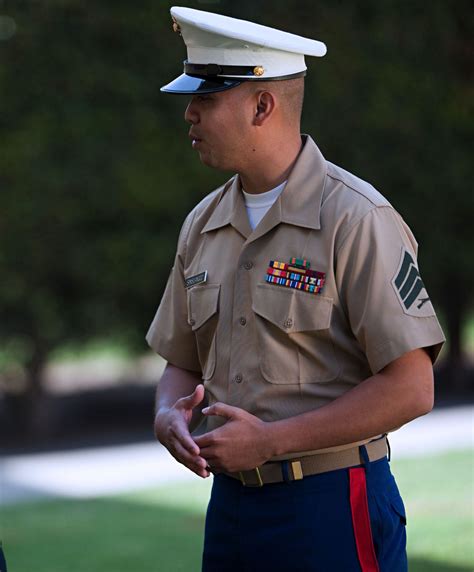 A Marine in dress uniform saluting during a ceremony