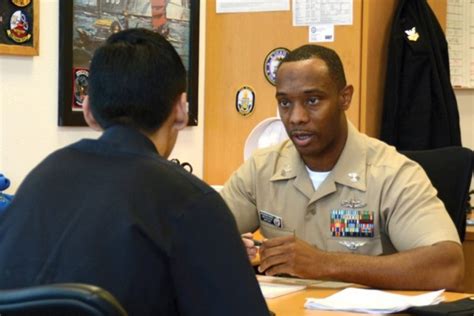 A Navy recruiter answering questions from a group of applicants