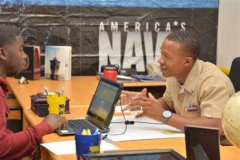 A Navy recruiter meeting with a group of applicants