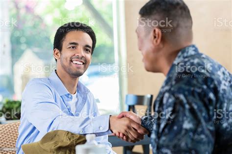 A Navy recruiter shaking hands with a young recruit