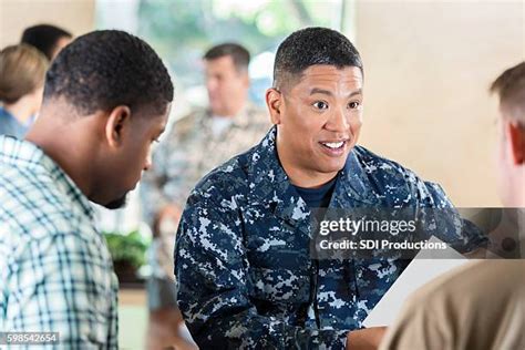 A photo of a Navy recruiting event, with recruiters and applicants shaking hands