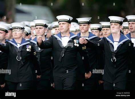 A group of sailors in uniform, with the American flag