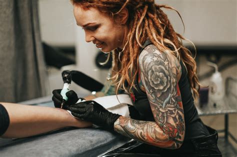 Person preparing for a tattoo session by researching and consulting with a tattoo artist