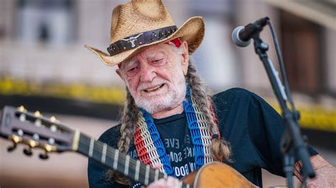 Willie Nelson playing his guitar