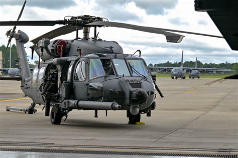 US Air Force HH-60 Pave Hawk flying over a forest landscape