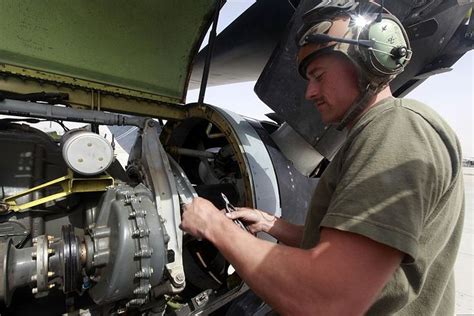 Aviation Mechanic in the Marine Corps collaborating with other mechanics