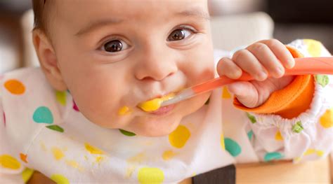 A person feeding a baby with a spoon