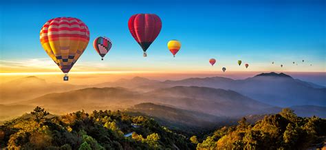 Hot air balloon flying over mountains