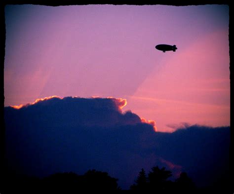 A blimp flying at sunset