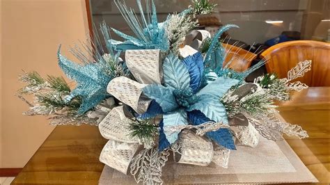 A blue Christmas tree decorated with a glittering garland made from blue and silver beads