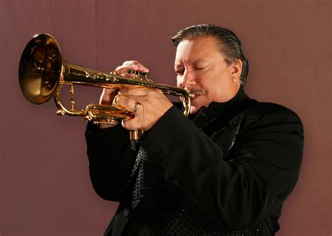 A bugle player performing at night, under stage lights