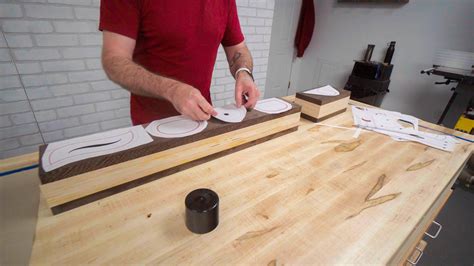 A person wearing safety goggles and a dust mask while using a bandsaw