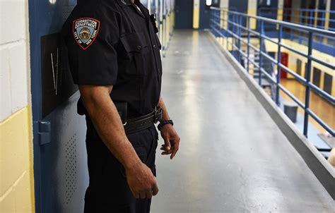 A Correctional Officer standing in front of a prison cellblock