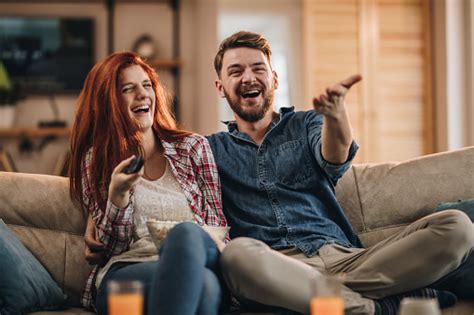 Couple laughing while watching TV