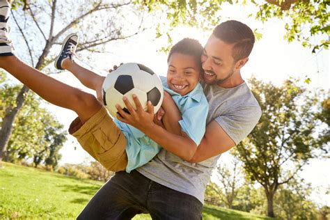 A photo of a dad playing sports with his kids