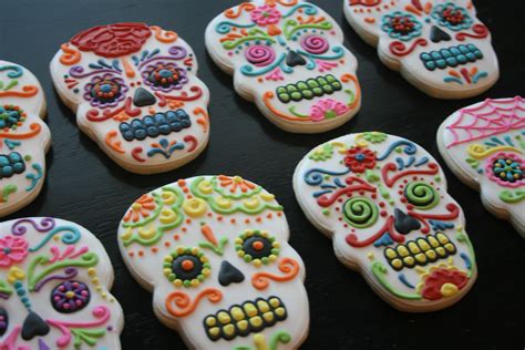 A person decorating a sugar skull with glitter and beads