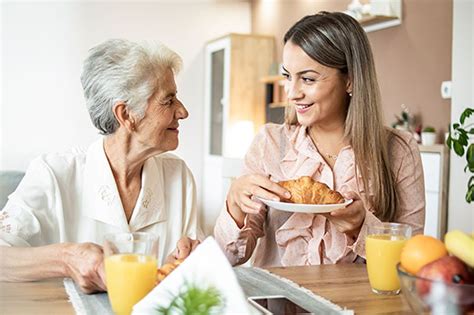 Elderly caregiver assisting senior with daily tasks