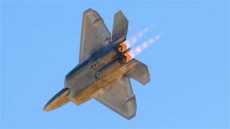 A fighter jet taking off with afterburners