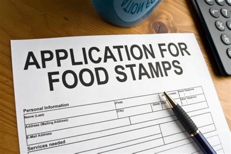 A person holding a tablet and smiling while filling out a food stamps application