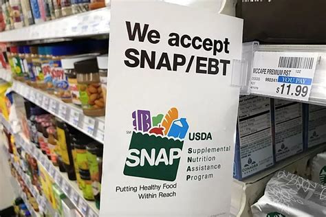 A person holding a food stamps card with a smile