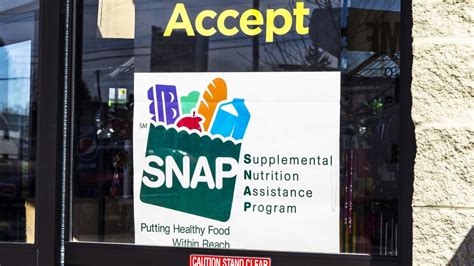 A person holding a food stamps card