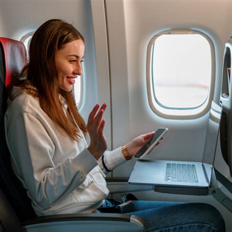 Flight attendant on a plane, smiling and looking out the window