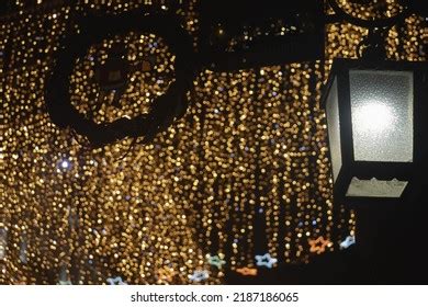 Garland wrapped around a street lamp with lights and ornaments