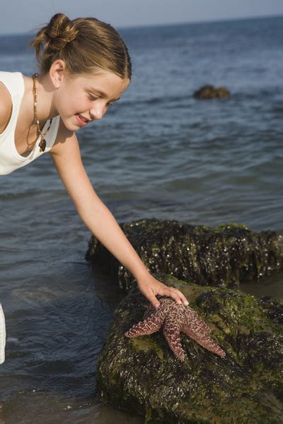 Girl picking up starfish