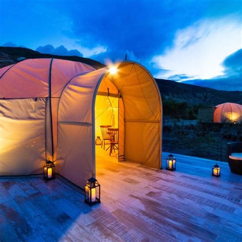 A luxurious glamping tent with a comfortable bed and furniture