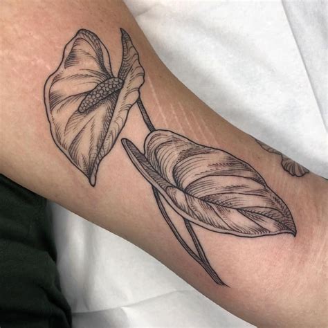 A detailed anthurium flower tattoo on the foot