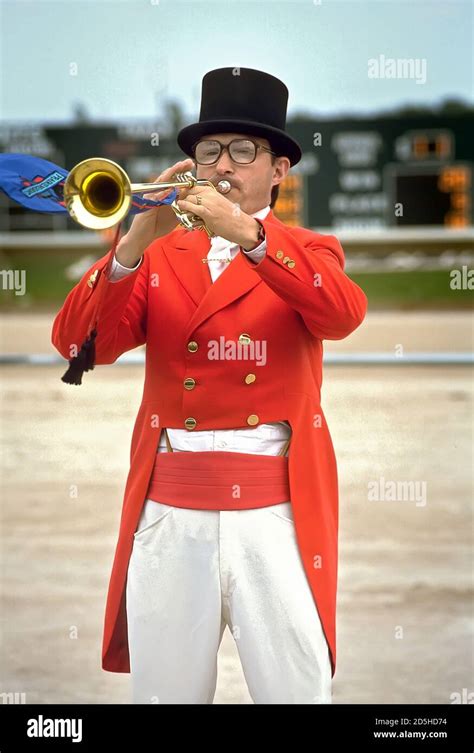 A bugler standing at a horse racing event