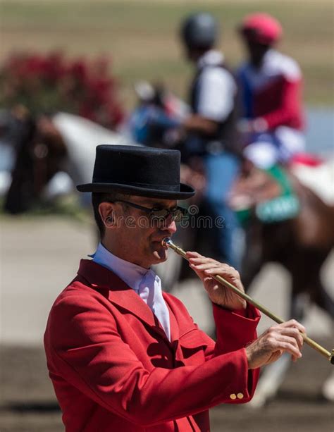 A bugler standing at a horse racing event