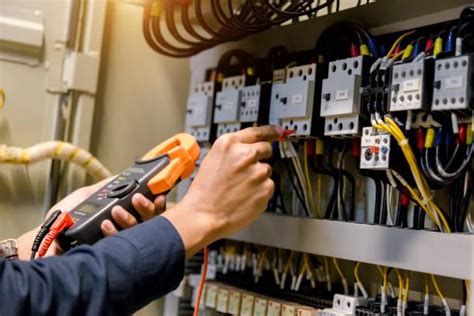 Electricians installing and commissioning electrical equipment in a power plant