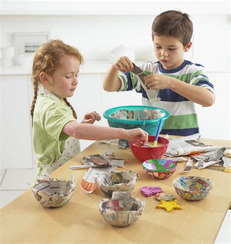 Kids engaged in various paper crafts, including cutting, gluing, and coloring