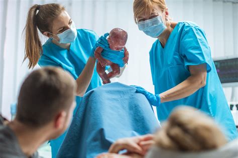 Labor and delivery nurse holding a newborn baby