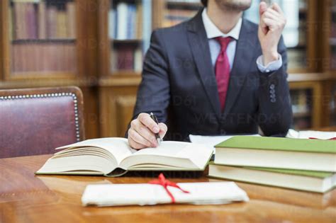 A lawyer sitting at a desk, surrounded by books and papers