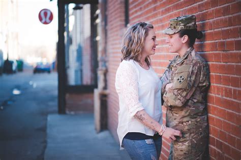 A photo of a female soldier with a rainbow flag