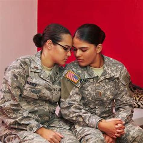 A photo of a female soldier holding a Pride flag