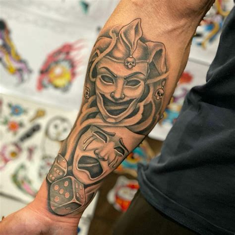 Mask tattoo design on a person's arm