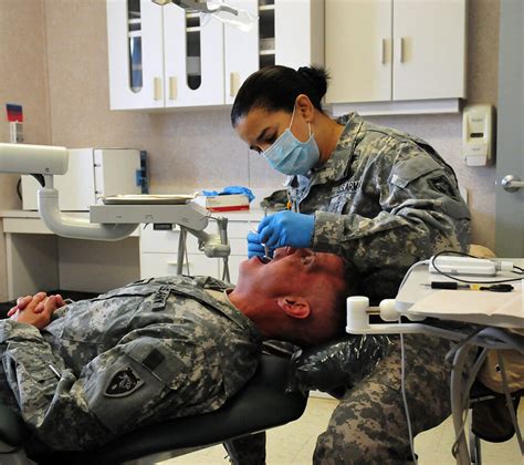 Military dentist examining patient