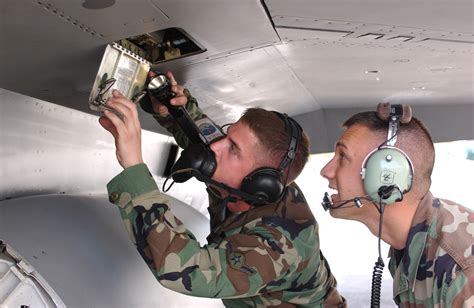 Military maintenance personnel working on a vehicle