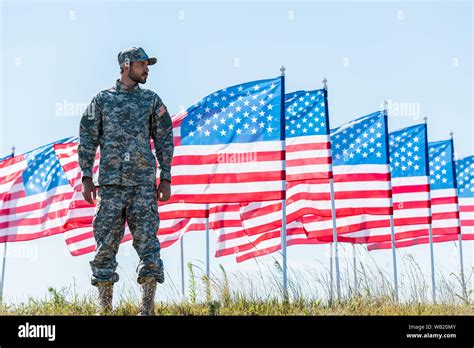 A soldier standing in front of a flag