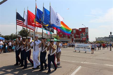 A photograph of a gay pride parade featuring service members