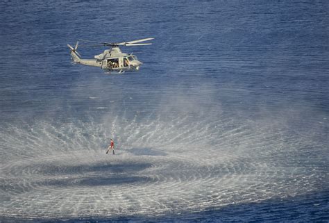 Navy Air Rescue Swimmers operating from a helicopter at sea