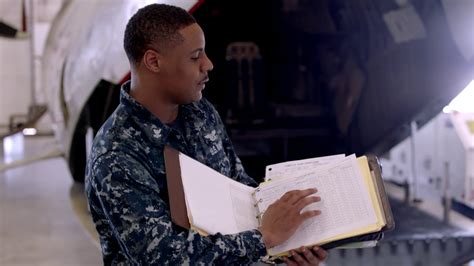 Navy drivers performing maintenance on a vehicle