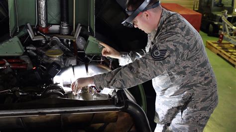 Navy driver performing maintenance on a vehicle